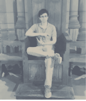 black and white of man sitting in wooden chair