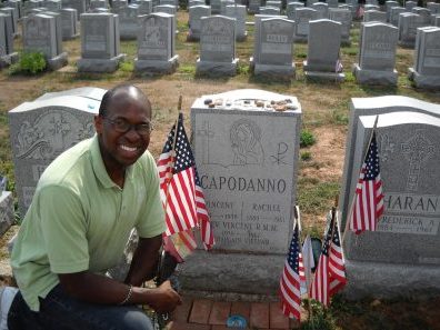 man crouching in front of grave