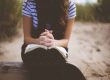 folded hands on book