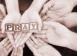 hands holding blocks that say pray