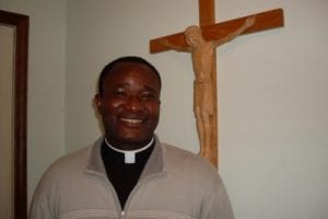 Priest in front of Crucifix