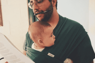 man working while holding child
